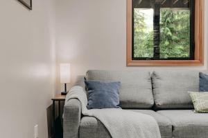 ein graues Sofa im Wohnzimmer mit Fenster in der Unterkunft 08MBR - Starlink - Gas F P - BBQ - Sleeps 2 home in Glacier
