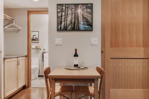 ein Esszimmer mit einem Tisch und einer Flasche Wein darauf in der Unterkunft 08MBR - Starlink - Gas F P - BBQ - Sleeps 2 home in Glacier