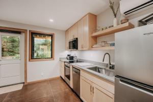 eine Küche mit einer Spüle und einem Kühlschrank in der Unterkunft 08MBR - Starlink - Gas F P - BBQ - Sleeps 2 home in Glacier