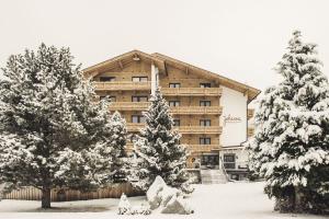 ein Gebäude mit schneebedeckten Bäumen davor in der Unterkunft Hotel Johanna mitten im Ötztal SUPERIOR in Umhausen