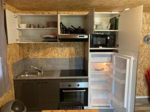een kleine keuken met een wastafel en een koelkast bij Chalet climatisé n°2 in Verrières