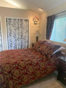 a bedroom with a bed with a red comforter and a window at Cozy Guesthouse- Individual Unit Private & Relaxing in Concord