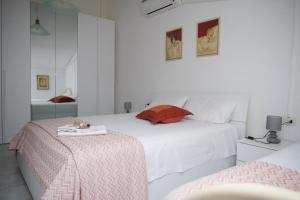 een witte slaapkamer met 2 bedden en een tafel bij Appartamento Casa Tonina in Carloforte