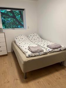 a unmade bed in a room with a window at BRAND NEW FLAT IN CENTRAL KLAKSVÍK in Klaksvík