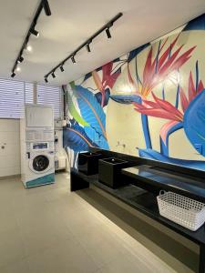 a bathroom with a washing machine and a colorful wall at Mundial Flat in Viçosa