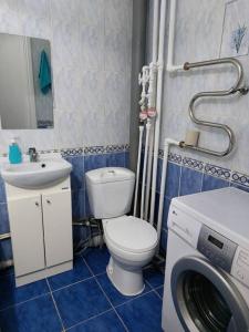 ein Badezimmer mit einem WC und einer Waschmaschine. in der Unterkunft Уютная квартира с удобным расположением in Līsakovsk