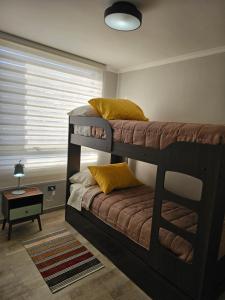 2 Etagenbetten in einem Zimmer mit Fenster in der Unterkunft Hermoso departamento de 2 dormitorios con una vista maravillosa in Valparaíso