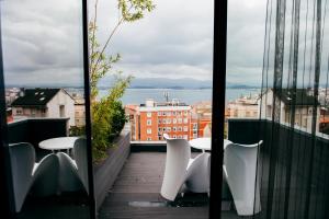 Hotel Art Santander في سانتاندير: بلكونه فيها طاولات وكراسي واطلاله على المدينه