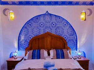 una camera con letto e testiera a motivi blu di Casa Meftah Blue a Chefchaouen