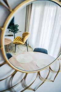 a reflection of a table and chairs in a mirror at Premium Sun Apartment in Vokolidha +57 photos
