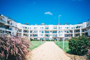 a large white apartment building with a brick driveway at Premium Sun Apartment in Vokolidha