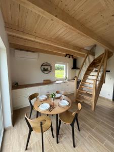 a kitchen and dining room with a wooden table and chairs at Białe Domki in Bytów