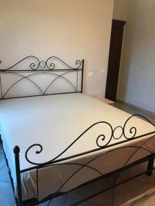 a bedroom with a black metal bed with white sheets at Villa Parisi in Fano