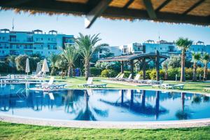 a swimming pool in a resort with tables and chairs at Premium Sun Apartment in Vokolidha