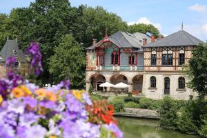 een groot huis met bloemen voor een rivier bij Cosy room - centre ville - 2 pers in Sarreguemines