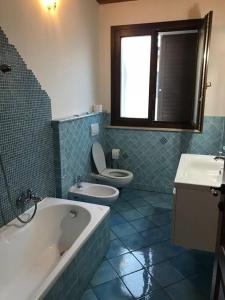 a bathroom with a tub and a toilet and a sink at Villa Parisi in Fano