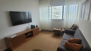 een woonkamer met een bank en een flatscreen-tv bij Uncle Brazil Lodging Ipanema in Rio de Janeiro