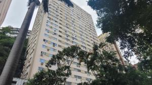 een hoog gebouw met een palmboom ervoor bij Uncle Brazil Lodging Ipanema in Rio de Janeiro