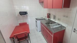 een kleine keuken met rode kasten en een wastafel bij Uncle Brazil Lodging Ipanema in Rio de Janeiro