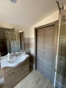 W łazience znajduje się umywalka, lustro i prysznic. w obiekcie Casa Vacanze a 10 km dal mare w mieście Carbonia