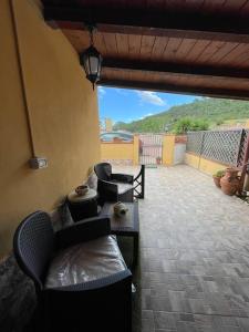 un patio con sofá y sillas en Casa Vacanze a 10 km dal mare en Carbonia