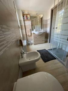 a bathroom with a toilet and a sink and a shower at Casa Vacanze a 10 km dal mare in Carbonia