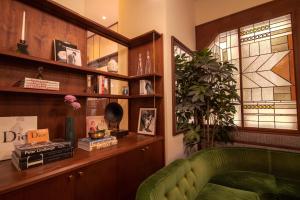 a living room with a green couch and a book shelf at The Evelyn NoMad in New York