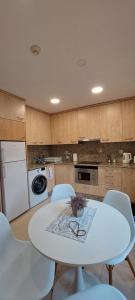 Biały stół i krzesła w kuchni w obiekcie Los Boliches Apartamentos Mediterraneo Real w mieście Fuengirola +3 zdjęcia