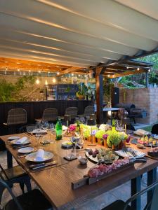 un lungo tavolo in legno con piatti e bicchieri da vino di Casa della Capra a Mergozzo