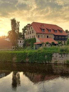 a large building next to a river with a building at Stary Młyn in Jelenia Góra