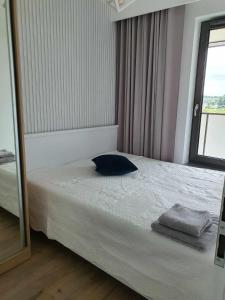 een slaapkamer met een bed met een spiegel en een raam bij Apartament Augustów ,Arnikowa in Augustów