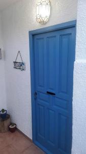 a blue door in a white wall with a light at Apartamento zona Parque Comercial in Mojácar