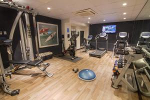 a gym with several treadmills and machines in a room at The Evelyn NoMad in New York