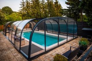 a swimming pool with a glass enclosure around a swimming pool at Respect Apartament in Hévíz