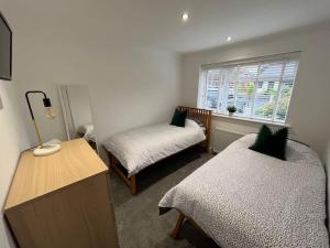 Cette chambre comprend 2 lits et une fenêtre. dans l'établissement Idyllic bungalow, ideal location in West Lancashire, à Burscough