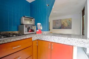 uma cozinha azul com uma bancada e um micro-ondas em Hostal en El Centro LaKiwa em Mazatlán