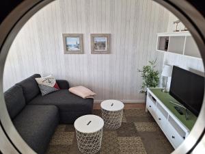 ein Wohnzimmer mit einem Sofa und einem TV in der Unterkunft Apartment Seeteufel in Büsum