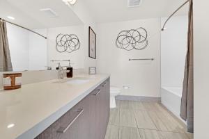Baño blanco con lavabo y aseo en Devereaux Miami Luxury One-Bedroom and Studios en Miami