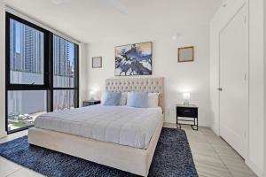 マイアミにあるDevereaux Miami Luxury One-Bedroom and Studiosの大きなベッドと大きな窓のある寝室