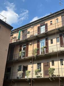 un bâtiment avec des balcons et des plantes en pot dans l'établissement Casa Savona - Tortona District - Self check-in, à Milan