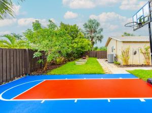 a basketball court in a backyard with a fence at Colorful Home - Pool - Game Room - Basketball Court - BBQ & More in Fort Lauderdale