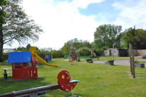 a park with a playground with a slide at Chalet Boerenbries - Heerlijk chalet met overkapt terras en 2 slaapkamers - max 4 pers - 3 km van Noordzee - locatie op camping Moorhoek 5 in Rockanje