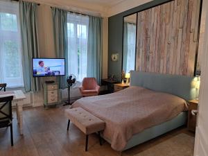 a bedroom with a bed and a flat screen tv at Gizella apartman in Budapest