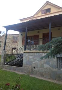 a house with a porch and a stone wall at Maroulas House in Chrysomiléa