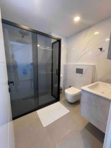 een badkamer met een douche, een toilet en een wastafel bij Villa Edis in Belek