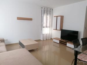 sala de estar con sofá y TV en Apartamento Moya - Playa y Sol, en Aguadulce