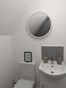 a white bathroom with a sink and a mirror at Myrtle Stables - converted, self-contained, countryside in Hernehill