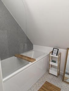 a white bath tub sitting in a bathroom with a shelf at Myrtle Stables - converted, self-contained, countryside in Hernehill