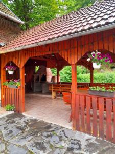 un pabellón de madera con bancos y flores en Casa Ursu, en Cârţişoara