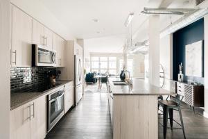 a kitchen with white cabinets and a counter top at Modern Industrial Loft - Center of RiNo Art District in Denver